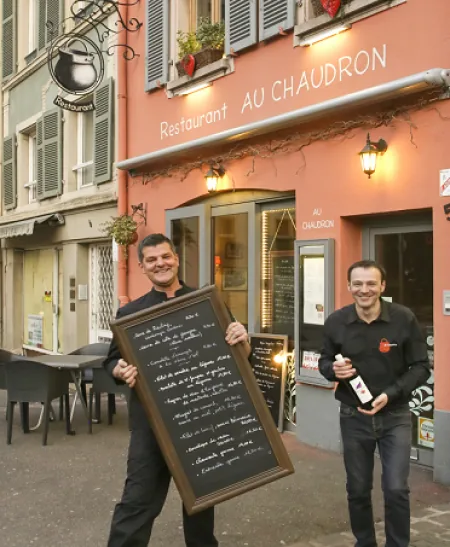 Le chef et son équipier devant la façade, avec l'ardoise du menu du jour