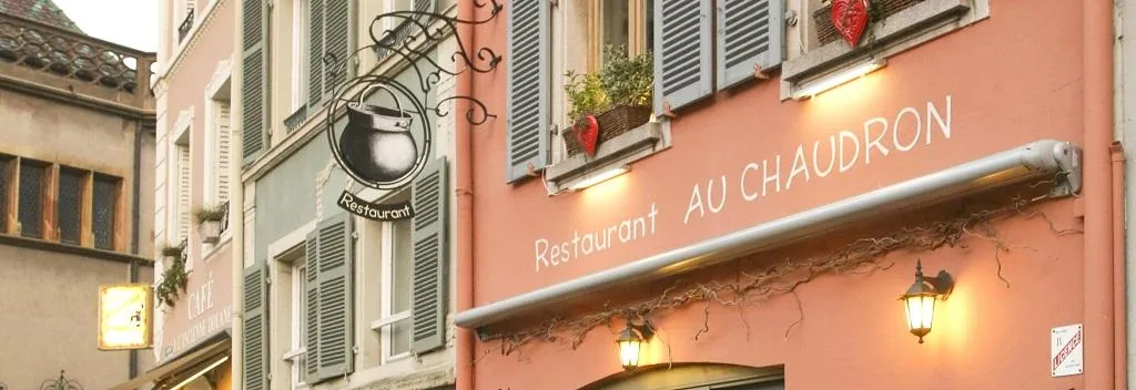 La façade saumon du restaurant et son enseigne en forme de chaudron